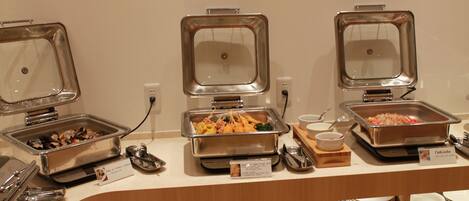 Una barra de buffet con diferentes opciones de comida y utensilios.