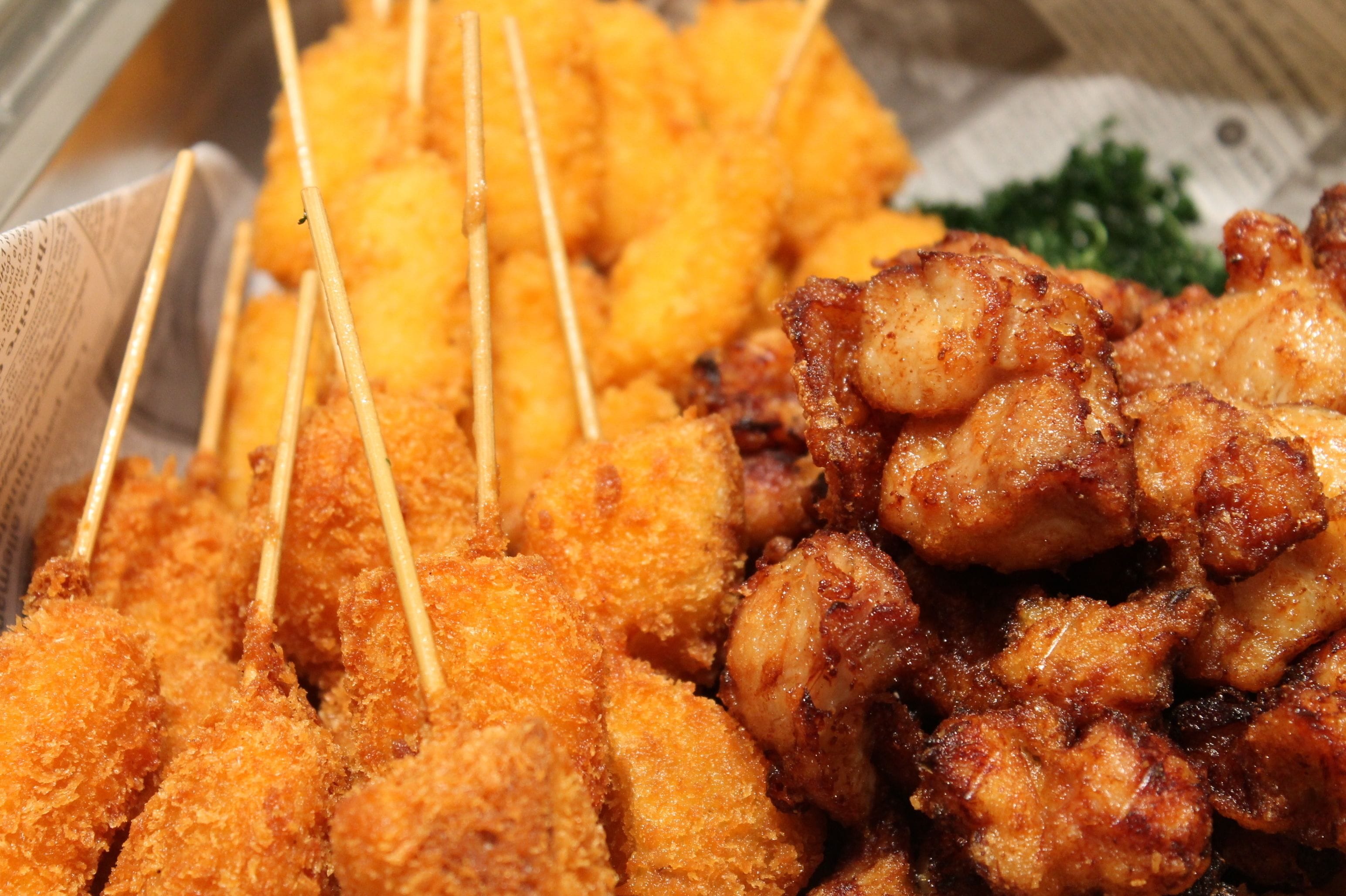 A tray of fried chicken skewers and fried chicken pieces.