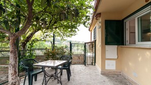 An outdoor patio with a table and chairs, a tree, and a view of the countryside. - COTTAGE cozy and comfortable (Roma)