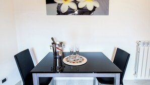 A dining table with a bottle of champagne, two glasses, and a plate with a floral design. - COTTAGE cozy and comfortable (Roma)