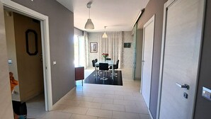 A hallway with a dining area, a door with a handle, and a light fixture. - Villa Gloria Maria, Swimming Pool - CIN:IT087024C2QQKFD6UP (Mascalucia)