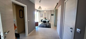 Un couloir comprenant un coin repas, une porte avec une poignée et un luminaire.