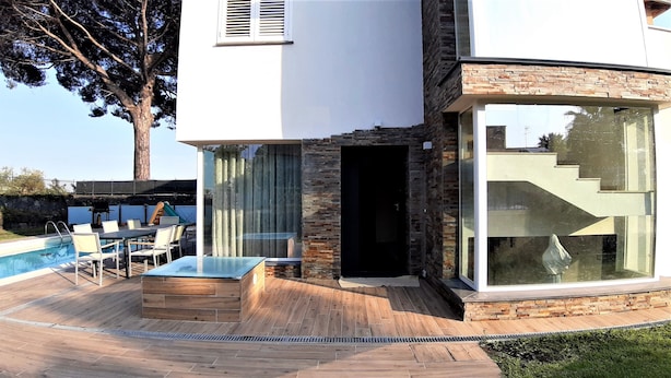 A modern house with a pool, outdoor seating, and a large glass door. - Villa Gloria Maria, Swimming Pool - CIN:IT087024C2QQKFD6UP (Mascalucia)