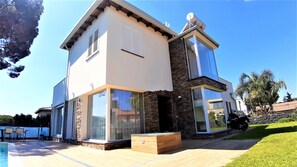 A modern two-story house with large glass windows, a stone facade, and a satellite dish on the roof. - Villa Gloria Maria, Swimming Pool - CIN:IT087024C2QQKFD6UP (Mascalucia)