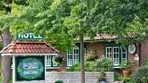 Un edificio de ladrillo tradicional con un letrero verde que indica un hotel.