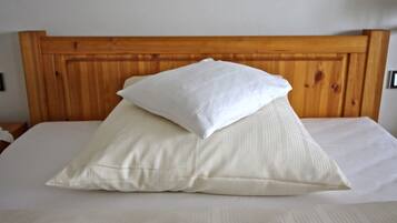 Una cama con cabecera de madera y dos almohadas.