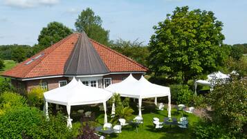 Traditional home surrounded by lush greenery and a well-maintained lawn, perfect for events and gatherings.