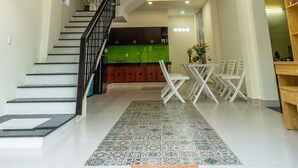 A spacious interior with a staircase, a dining area, and a kitchen. - D Central Homestay Hoi An (Da Nang)