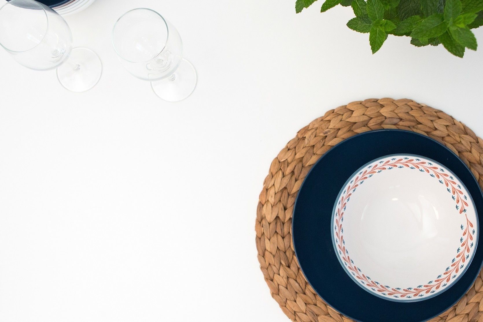 A woven placemat with a decorative plate on a white surface.