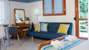 Una camera da letto con un letto, una scrivania, una sedia, un divano, uno specchio e una finestra.