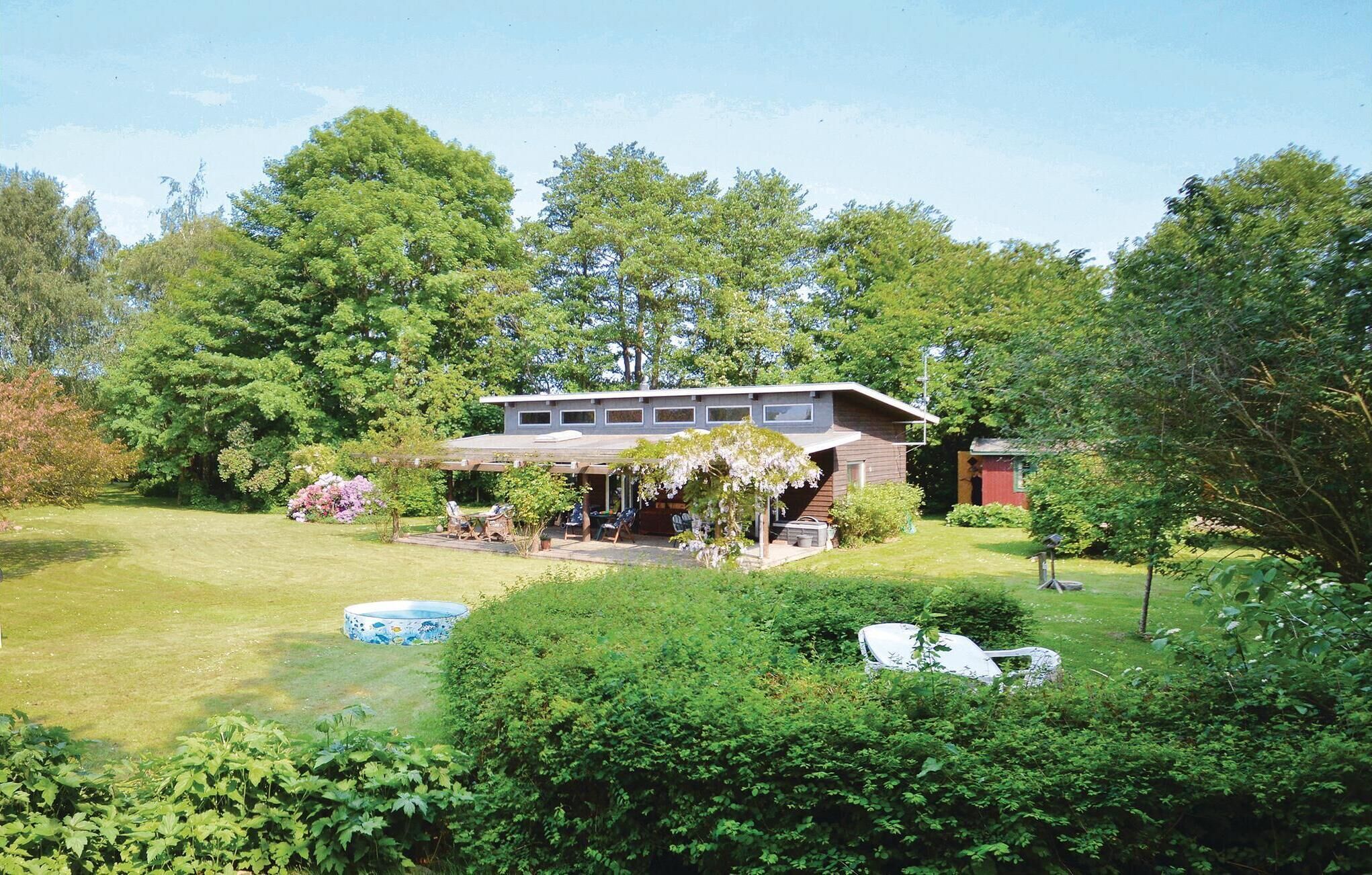 A modern two-story house with a covered patio and a swimming pool in the yard.