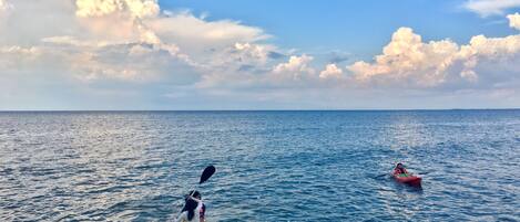 Two kayaks on a calm sea with a clear sky.
