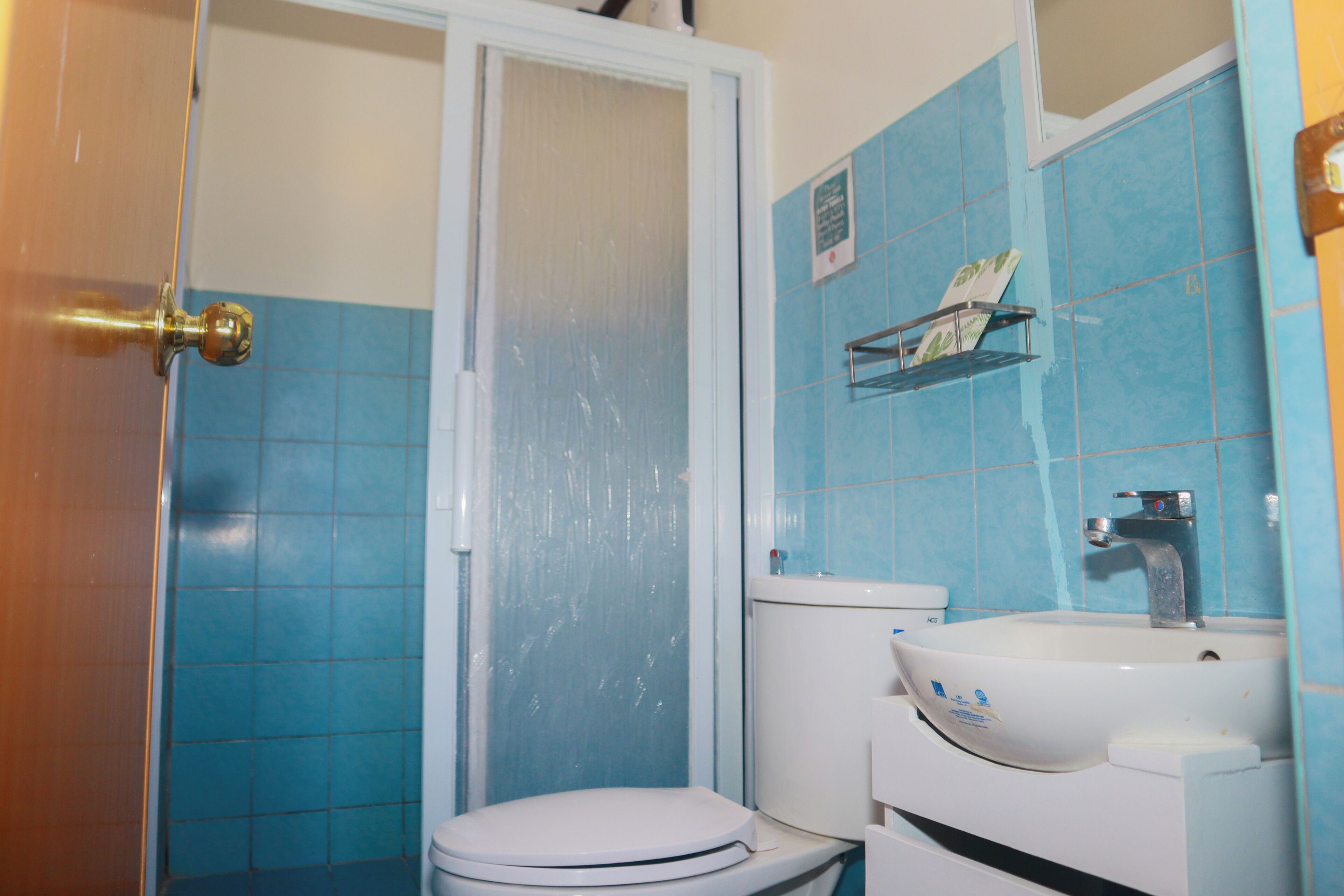 Un baño con inodoro, lavamanos y zona de ducha.