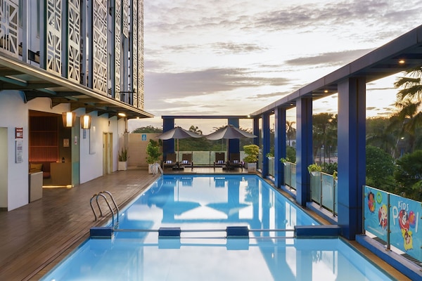 Una piscina al aire libre, tumbonas