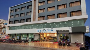 Un hôtel appelé « Anaya Beacon Hotel - Jammaghar », doté d’un design moderne, de plusieurs étages et d’une entrée bien visible agrémentée de plantes en pot.