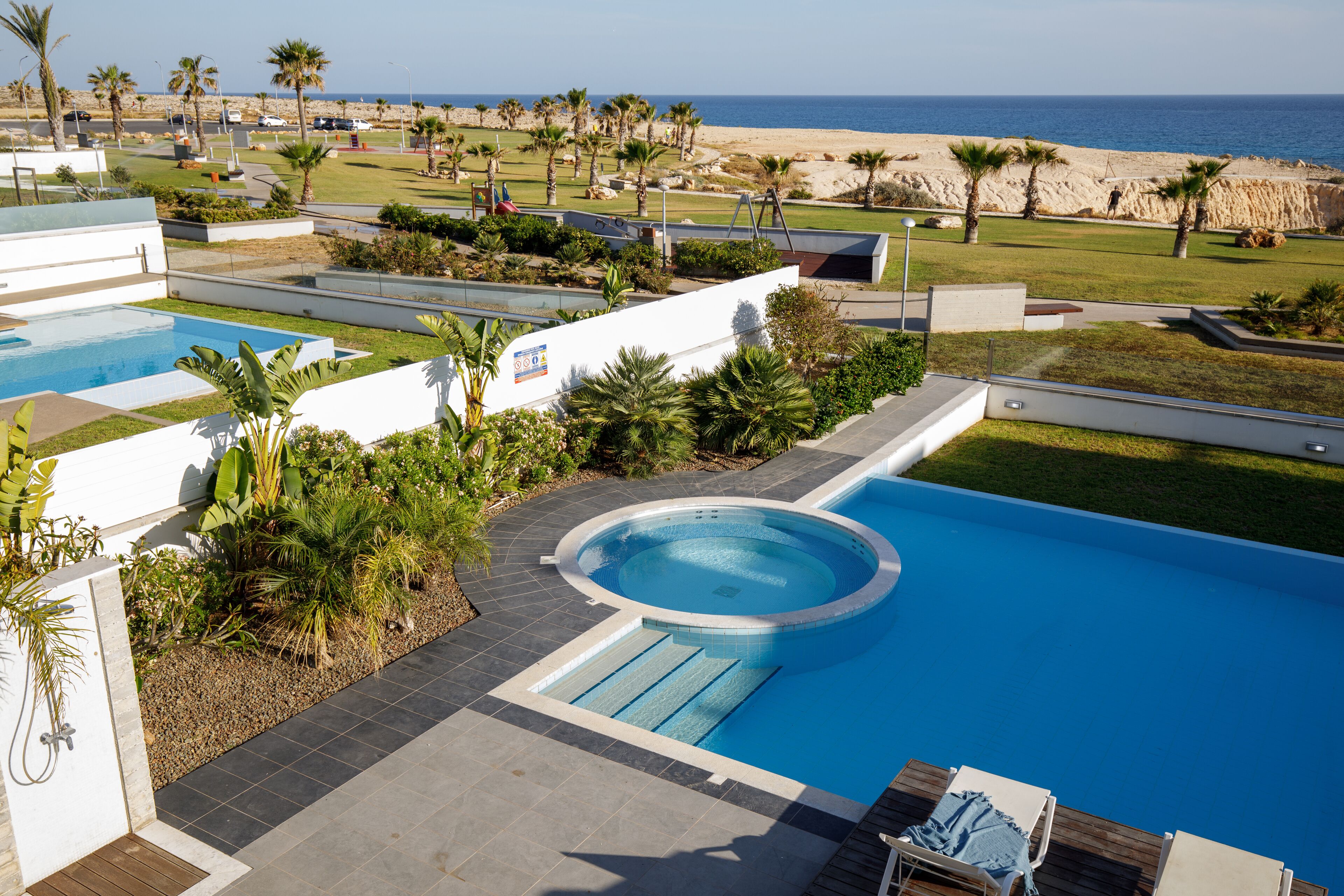 Een resort met meerdere zwembaden, uitzicht op het strand en een goed onderhouden tuin.