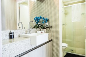A bathroom with a sink, mirror, and shower area. - Landscape Diamond (Fortaleza)