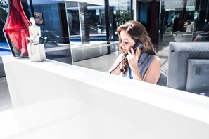 A reception desk with a white sculpture, a glass window, and a modern interior design. - Landscape Diamond (Fortaleza)