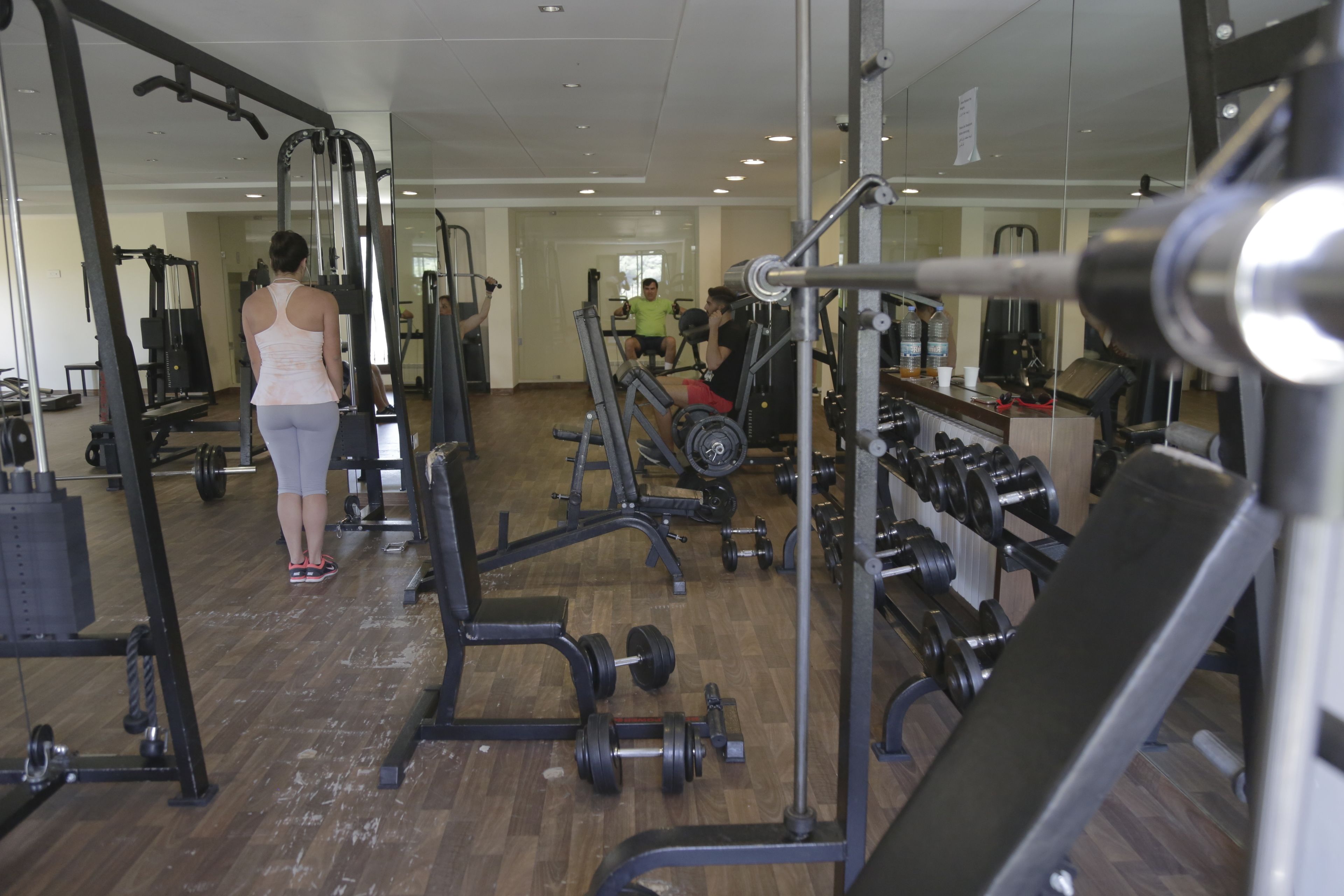 A gym with various exercise equipment, including weight machines and dumbbells.