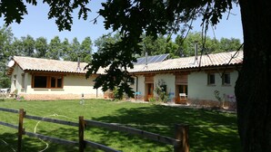 A house with a tiled roof, solar panels, and a fenced yard.