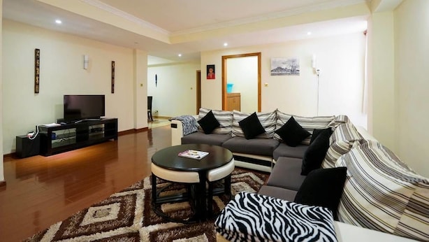 A living room with a sofa, a coffee table, and a TV on a stand.