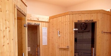 Uma sala de sauna com paredes de madeira, uma porta com a inscrição "BIO-SAUNA" e um relógio na parede.