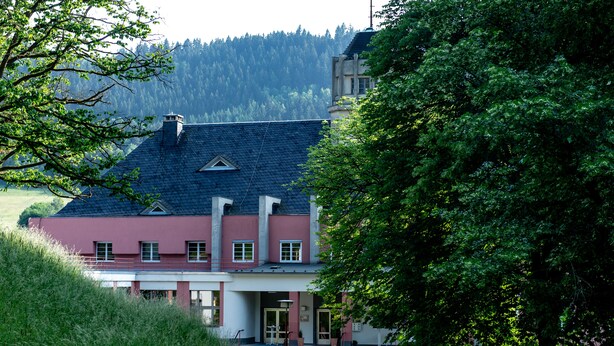 Un bâtiment doté d’un toit en pente, d’une façade rouge et d’un escalier menant à l’entrée.