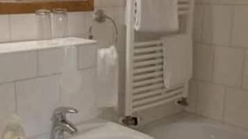 Casa de banho com lavatório, espelho e banheira.