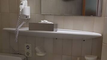 Ein Badezimmer mit Toilette, Waschbecken und einem Spiegel darüber.