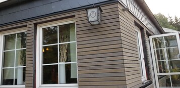 Un edificio con grandes ventanales y fachada de madera.