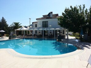 Piscine extérieure, parasols de plage, chaises longues