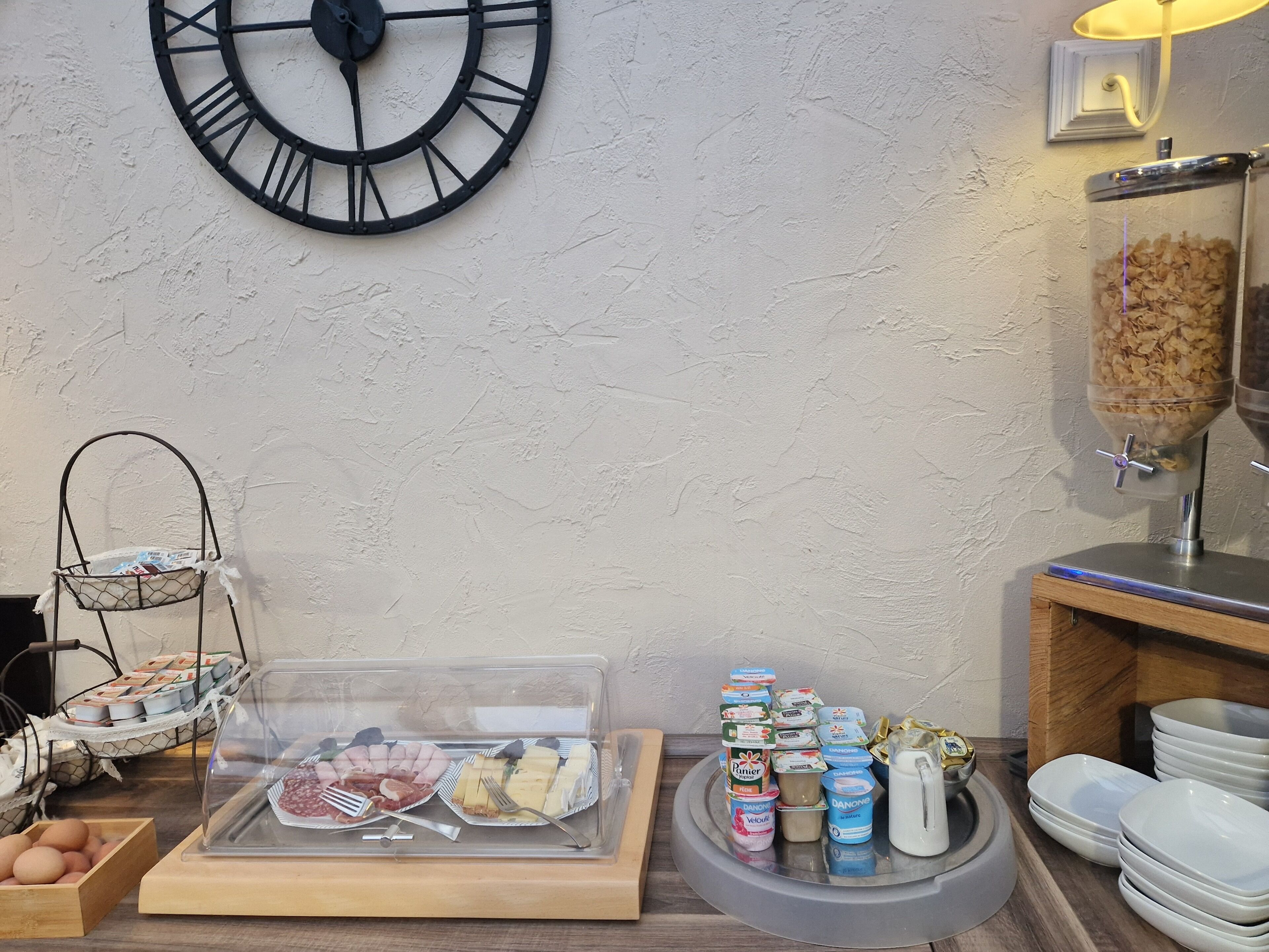 Un bufé de desayuno con diversos alimentos, un reloj y una cafetera.