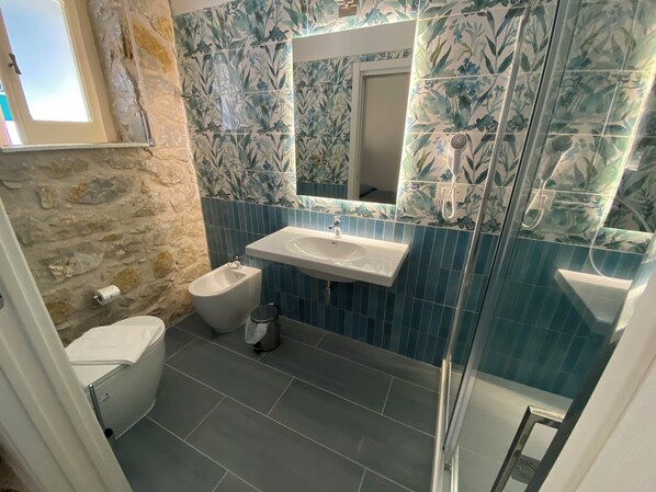 A bathroom with a bidet, a sink, and a mirror. - Cinquestelle-albergo del centro storico (Centola)