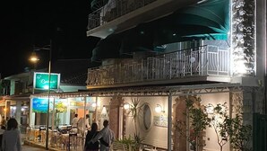 A restaurant with outdoor seating, a signboard, and a staircase leading to an upper level. - Cinquestelle-albergo del centro storico (Centola)