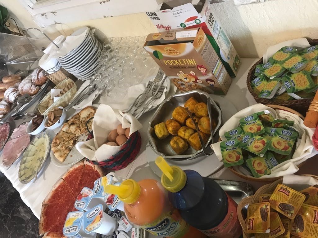 Un tavolo per buffet con diversi cibi, tra cui pasticcini, frutta e condimenti.