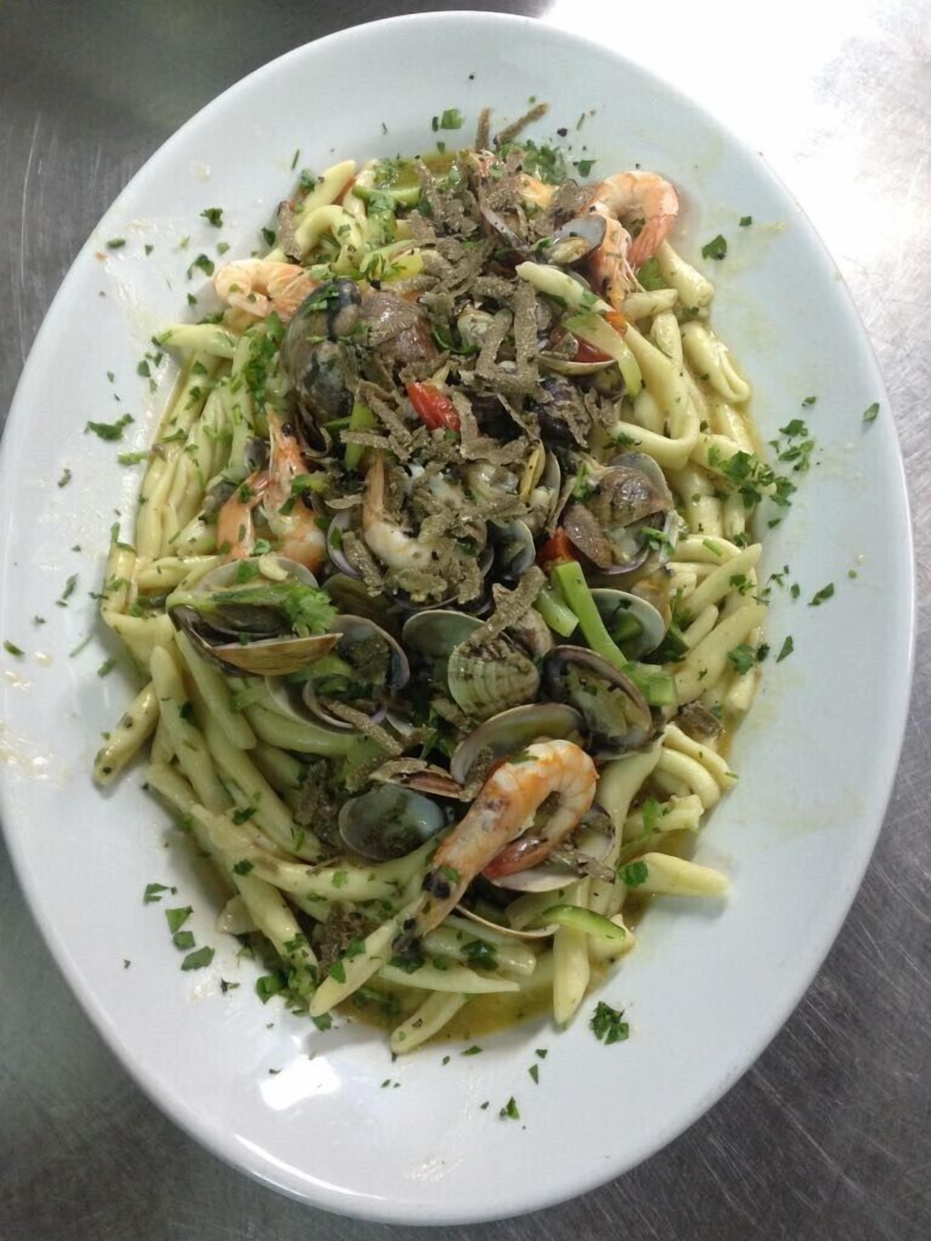 Un plato de pasta con almejas y camarones.