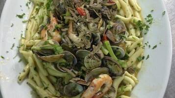 Un plato de pasta con almejas y camarones.