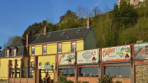 Un bâtiment jaune avec une enseigne indiquant « Hôtel-Restaurant » et « Carrefour ».