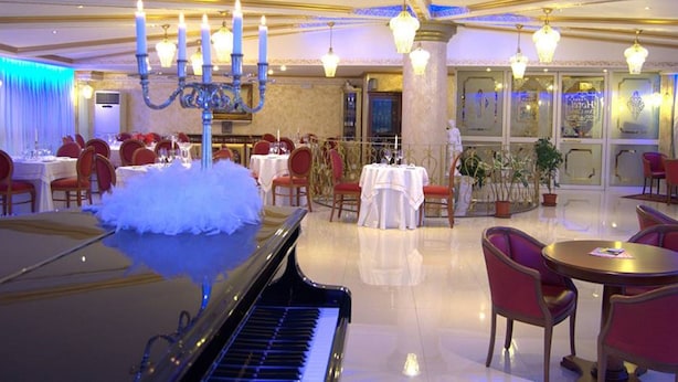 A grand dining hall with a piano, chandeliers, and red chairs. - Hotel Don Carlo 4S (San Marco Argentano)