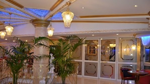 A luxurious lobby with ornate columns, large potted plants, and elegant chandeliers. - Hotel Don Carlo 4S (San Marco Argentano)
