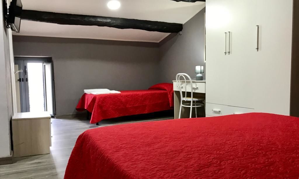 Una camera da letto con due letti, una scrivania e una sedia.