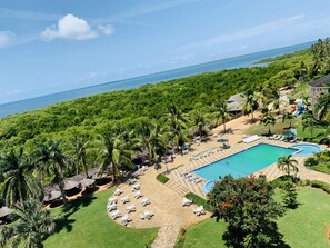 A resort with a swimming pool, lounge chairs, and a view of the ocean. - Tanga Beach Resort & Spa (Tanga)