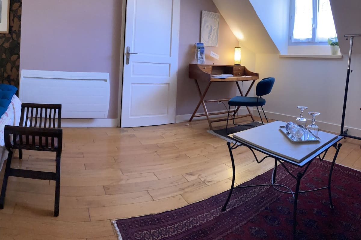 Un dormitorio con una cama grande, un escritorio y una silla.