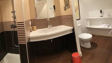 A modern bathroom with a curved sink, a shower, and a toilet.