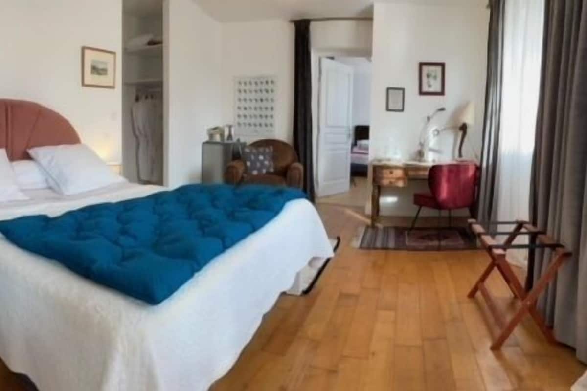 Un dormitorio con una cama, una mesita de noche, un escritorio y una silla.