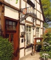 Una casa tradicional con entramado de madera, con una ventana, una puerta y un pequeño porche.
