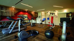 Un gimnasio con cintas de correr, bicicletas estáticas y pelotas de ejercicio.