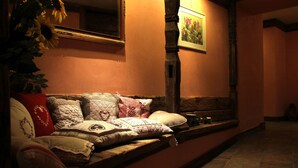 Una habitación acogedora con un banco de madera, un banco acolchado con cojines decorativos, un espejo y un cuadro en la pared.