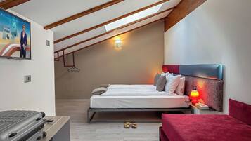 Quarto moderno com teto estilo loft, cama com roupa de cama branca, parede de destaque vermelha e uma pequena mesa de cabeceira com abajur.