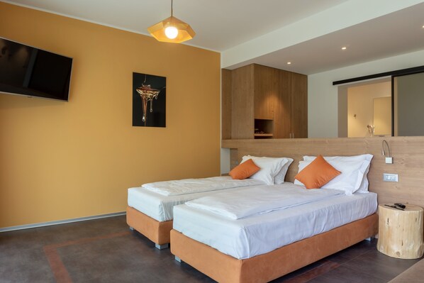 A modern hotel room with two beds, a mounted TV, and a wooden headboard. - O-live Agriresort (Arco)